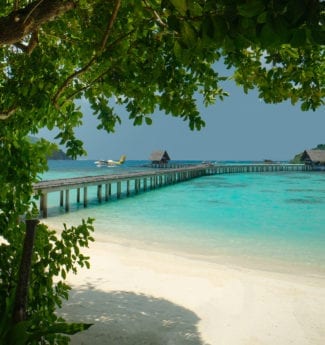 Instagrammable backdrop with iconic fishtail jetty and seaplane on the vast turquoise lagoon at Bawah Reserve, Indonesia