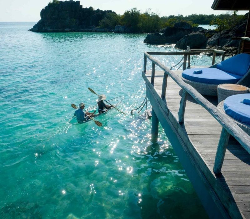 Couple kayaking with a transparent kayak in the crystal clear lagoons at Bawah Reserve, Indonesia