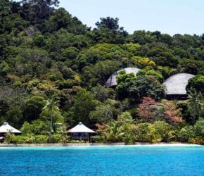 View of the beach suites lining at beach front on private island sustainable resort Bawah Reserve, Indonesia