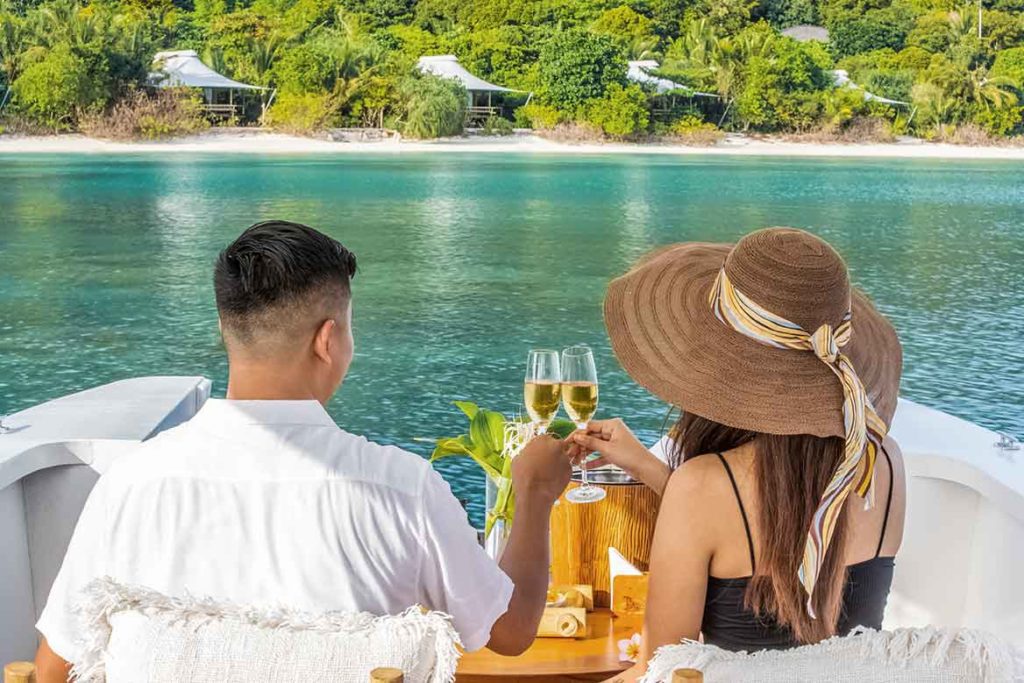 couple drinking champagne on boat in lagoon