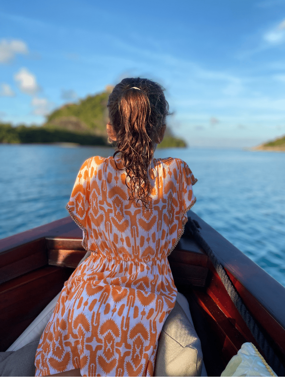 Child enjoying a boat, kids and family activities at Bawah Reserve, Indonesia.