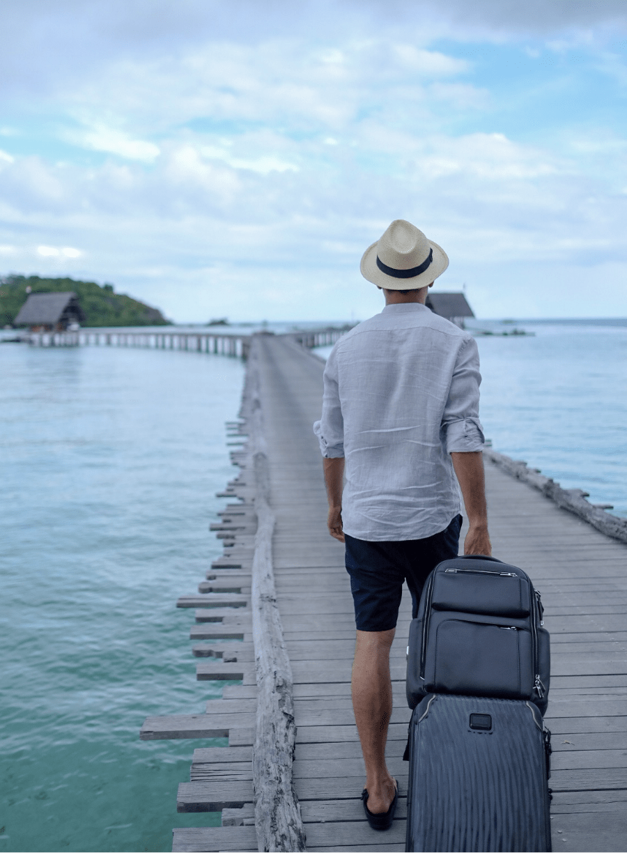 Guest walking towards seaplane along the jetty with his suitcase. Learn what best to pack for a trip to Bawah Reserve, Indonesia.