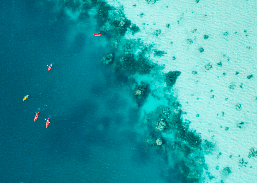 Group of kayakers, aerial view, blue lagoon at Bawah Reserve, Indonesia.